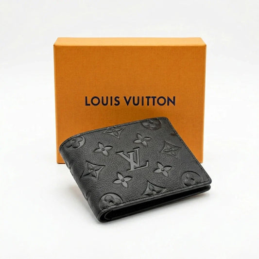 A black Louis Vuitton bi-fold wallet with the embossed monogram pattern, displayed in front of its signature orange brand box on a clean white background.