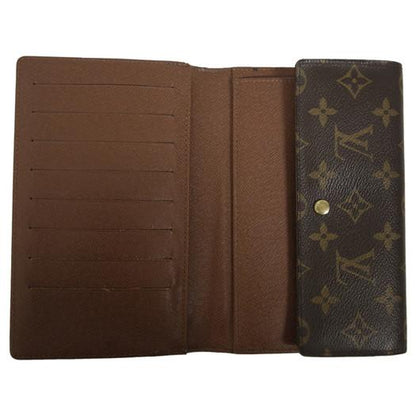 An open brown leather wallet or bifold with multiple card slots on the left and a monogram-patterned flap on the right, photographed on a plain white background.