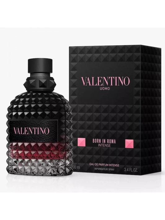 Valentino Uomo Born in Roma Intense Eau de Parfum Intense bottle with a textured black cap and base, showing a deep red liquid inside, next to its black geometric packaging box with pink lettering.